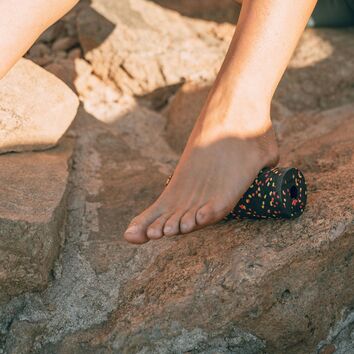 nackter Fuß wird mit einer Minifaszienrolle mobilisiert