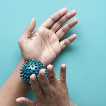 Rechte Hand massiert linken Unterarm mit einem Igelball